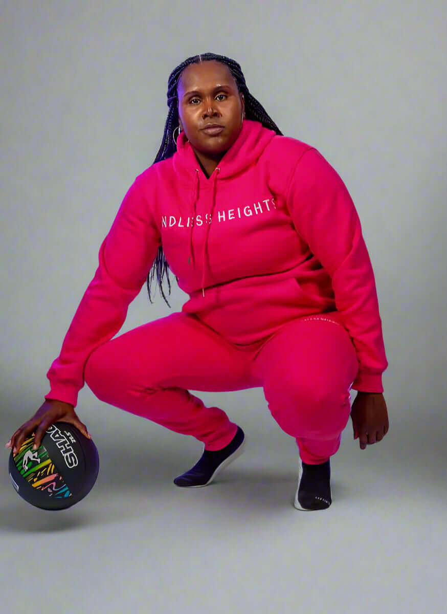 Model wearing pink tracksuit from Taller Than LIfe Collection, promoting the ENDLESS HEIGHTS lifestyle.