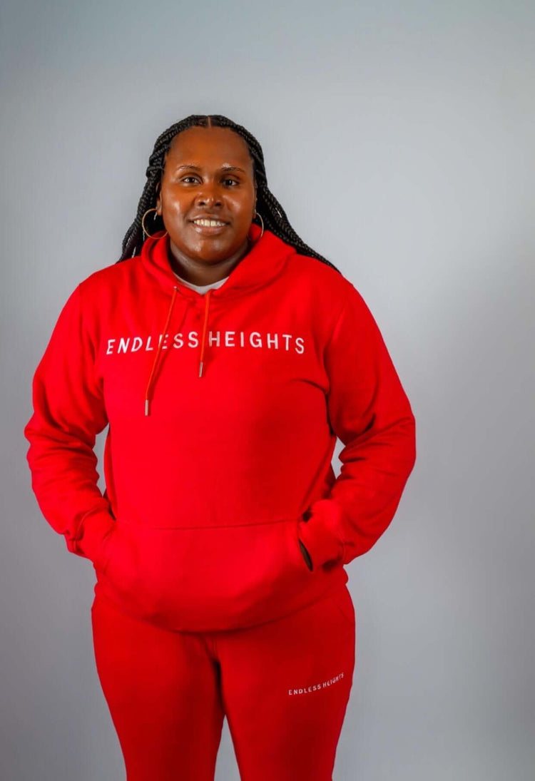 Model wearing red Sky High Stacked jogging set from ENDLESS HEIGHTS, showcasing casual athletic style.