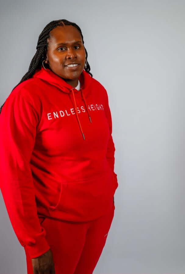 Sky High Stacked Jogging Sets in vibrant red, worn by a smiling model showcasing the ENDLESS HEIGHTS tracksuit.