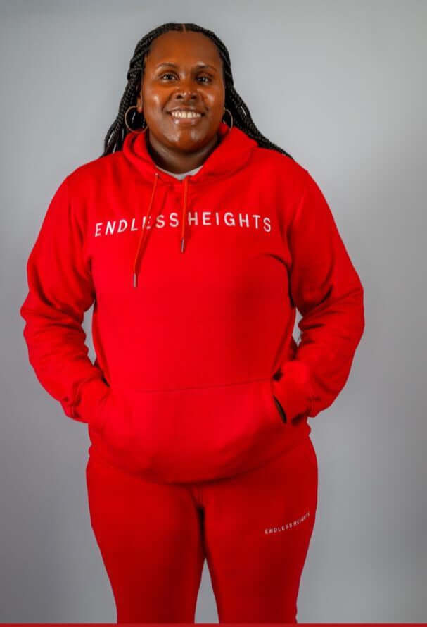 Model wearing a red Sky High Stacked jogging set from ENDLESS HEIGHTS collection, showcasing casual style.