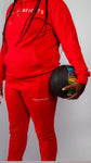 Sky High Stacked Jogging Set in red featuring Endless Heights logo, held by a person with a colorful ball.